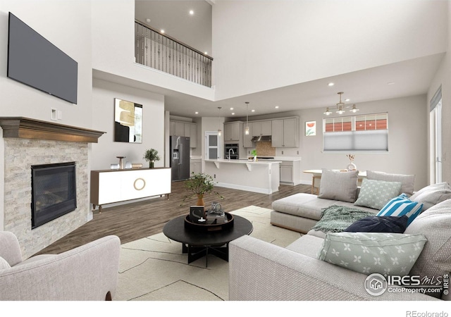1863 Pioneer Cir, Lafayette, CO 80026 - living area featuring wood finished floors, a stone fireplace, a towering ceiling, and recessed lighting