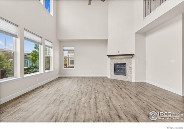 1863 Pioneer Cir, Lafayette, CO 80026 - unfurnished living room with a high ceiling, wood finished floors, and a glass covered fireplace