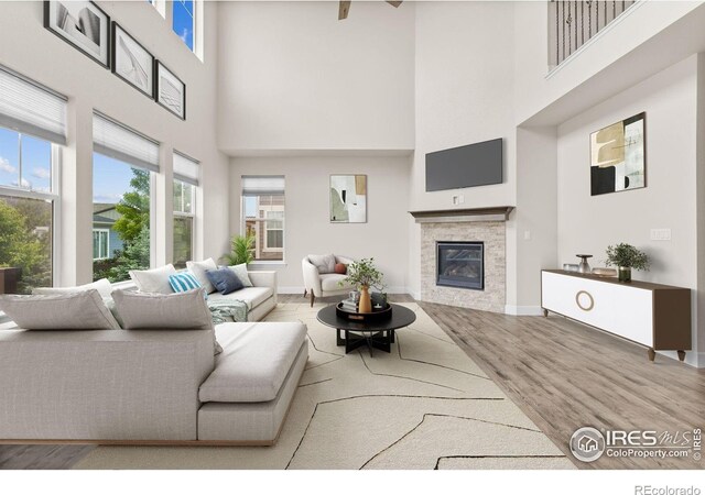 1863 Pioneer Cir, Lafayette, CO 80026 - living room featuring a high ceiling, a glass covered fireplace, and wood finished floors