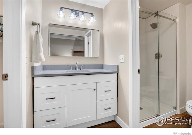 8940 W 80th Dr, Arvada, CO 80005 - full bath featuring a stall shower, vanity, and wood finished floors