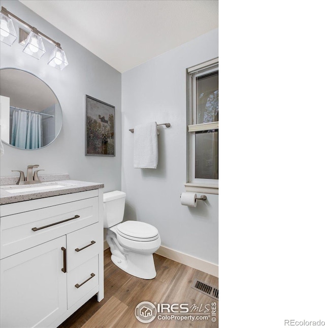 8940 W 80th Dr, Arvada, CO 80005 - full bathroom featuring wood finished floors, vanity, and a shower with shower curtain
