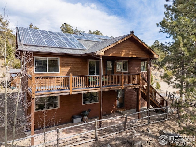 317 W 5th St, Nederland, CO 80466 - view of front facade featuring solar panels, a shingled roof, a fenced backyard, and stairway