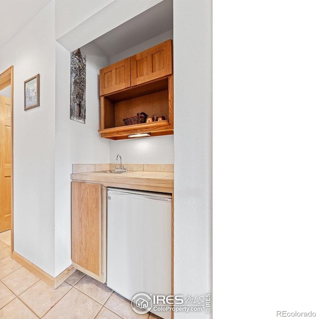 317 W 5th St, Nederland, CO 80466 - indoor wet bar featuring fridge, light tile patterned floors, and baseboards