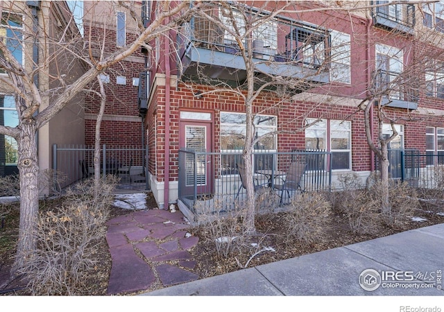 view of front of house with a balcony and brick siding