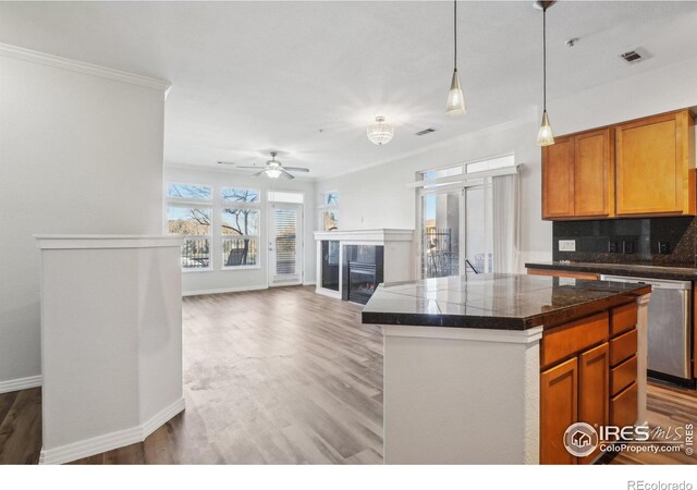 kitchen with backsplash, tile counters, wood finished floors, dishwasher, and visible vents