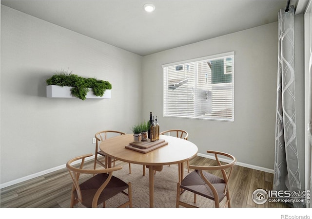 dining room featuring baseboards, wood finished floors, and recessed lighting