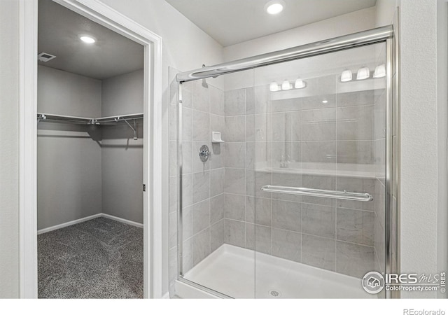 full bath featuring a stall shower and a spacious closet
