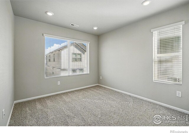 unfurnished room featuring baseboards, carpet floors, visible vents, and recessed lighting