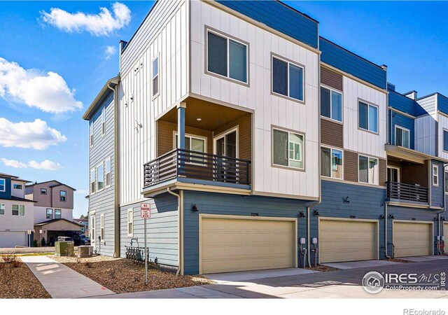 multi unit property featuring an attached garage, board and batten siding, and a residential view