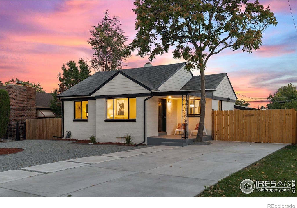 view of front of home featuring fence, crawl space, brick siding, a porch, and a shingled roof