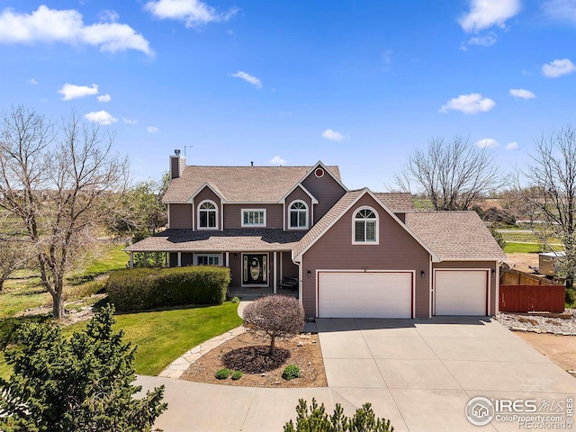view of front of home featuring fence, an attached garage, driveway, a front lawn, and a chimney