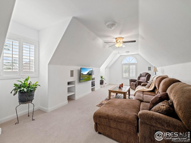 living room with a ceiling fan, lofted ceiling, built in features, baseboards, and carpet