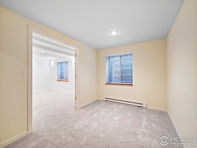 empty room with carpet flooring, baseboards, and baseboard heating