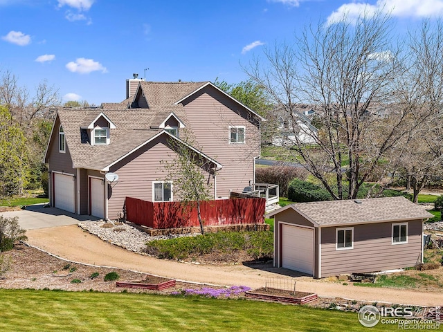 view of home's exterior with driveway, a chimney, a shingled roof, a garage, and a yard