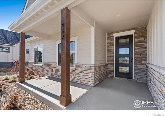 1402 Burt Ave, Berthoud, CO 80513 - view of exterior entry with stone siding and a porch