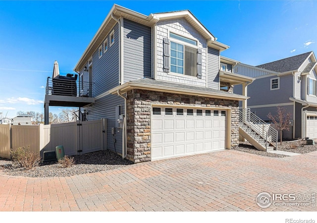 3536 Valleywood Ct, Johnstown, CO 80534 - view of front of property with stairway, fence, stone siding, decorative driveway, and a garage