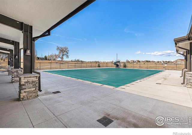3536 Valleywood Ct, Johnstown, CO 80534 - view of swimming pool featuring a patio, a fenced in pool, a fenced backyard, and a water slide