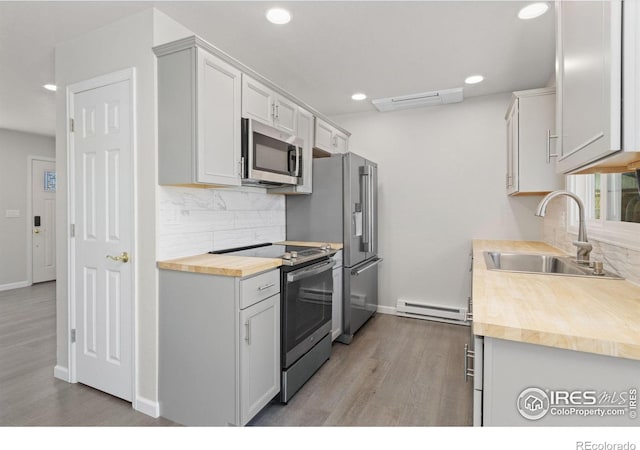 2836 Adobe Dr, Fort Collins, CO 80525 - kitchen featuring a sink, backsplash, butcher block countertops, appliances with stainless steel finishes, and a baseboard heating unit