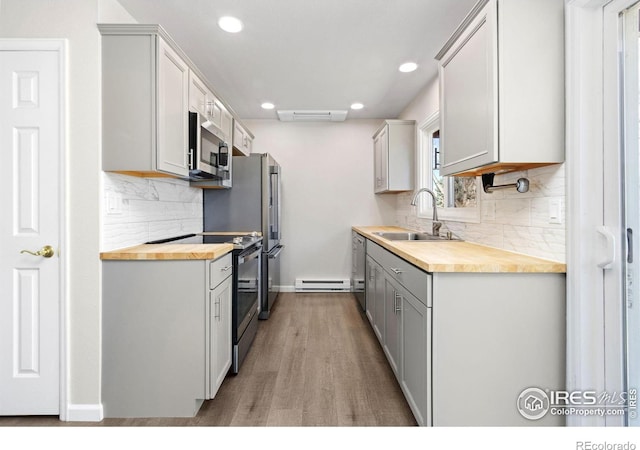 2836 Adobe Dr, Fort Collins, CO 80525 - kitchen with backsplash, wooden counters, a sink, appliances with stainless steel finishes, and wood finished floors