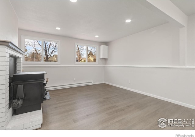 2836 Adobe Dr, Fort Collins, CO 80525 - interior space with light wood-style flooring, baseboards, a baseboard heating unit, and a wood stove