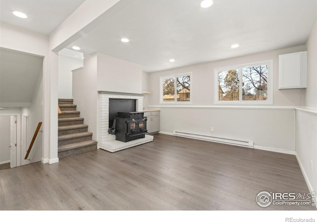 2836 Adobe Dr, Fort Collins, CO 80525 - unfurnished living room with light wood finished floors, a baseboard radiator, recessed lighting, stairway, and a wood stove