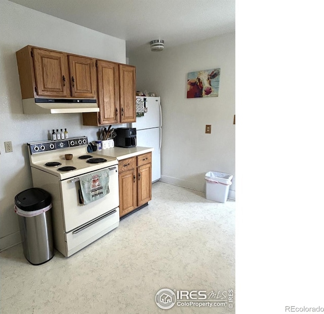 730 Lake St, Fort Morgan, CO 80701 - kitchen featuring white appliances, light countertops, brown cabinets, and under cabinet range hood