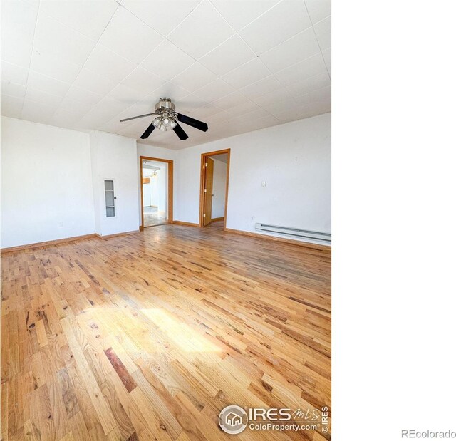 3828 Mckinley Ave, Wellington, CO 80549 - empty room featuring ceiling fan, baseboards, a baseboard heating unit, and wood finished floors