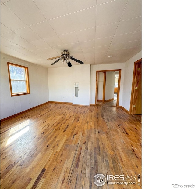 3828 Mckinley Ave, Wellington, CO 80549 - unfurnished living room with baseboards, light wood-style floors, and a ceiling fan