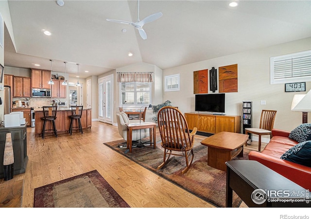 living room with recessed lighting, lofted ceiling, ceiling fan, and light wood-type flooring