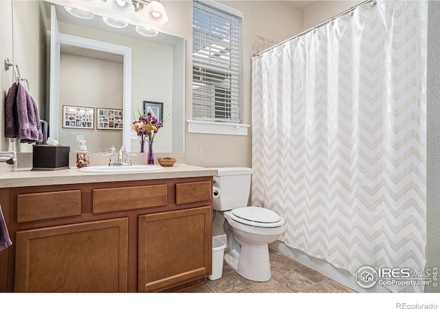 bathroom featuring a shower with curtain, toilet, vanity, and tile patterned floors