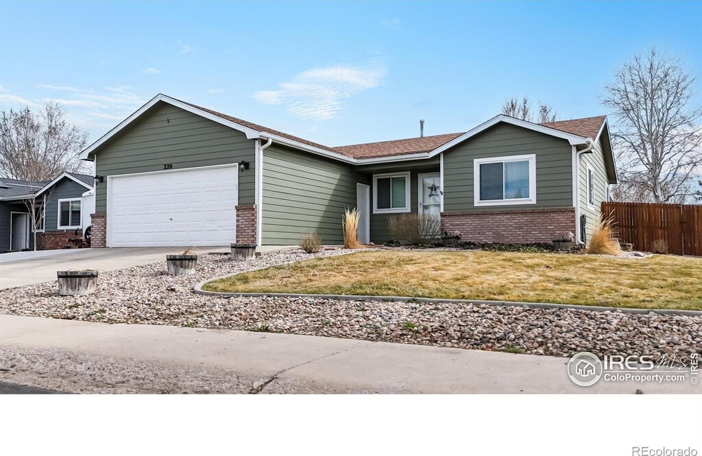 220 E Ilex St, Milliken, CO 80543 - ranch-style home with fence, an attached garage, brick siding, a front lawn, and driveway