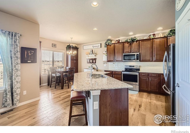 5460 Homeward Dr, Timnath, CO 80547 - kitchen featuring appliances with stainless steel finishes, a sink, a chandelier, light wood-style floors, and recessed lighting