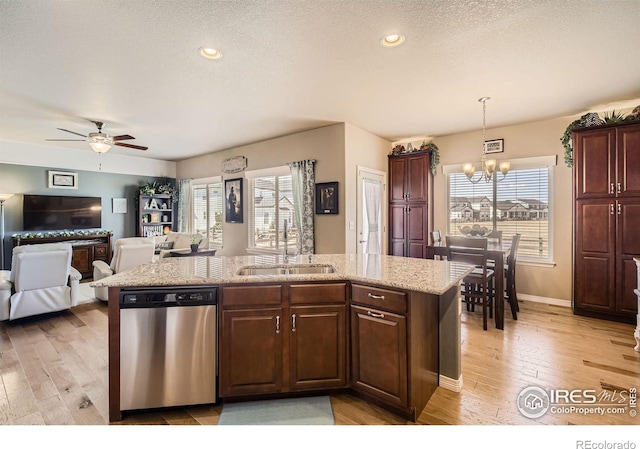 5460 Homeward Dr, Timnath, CO 80547 - kitchen with stainless steel dishwasher, a sink, a chandelier, light wood finished floors, and a textured ceiling