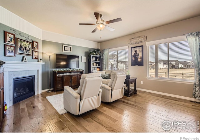 5460 Homeward Dr, Timnath, CO 80547 - living room featuring baseboards, a ceiling fan, hardwood / wood-style flooring, and a tiled fireplace