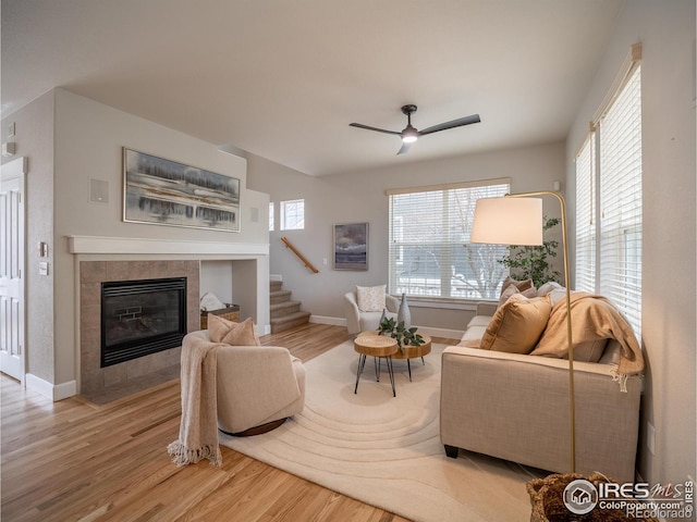2946 Shoshone Trl, Lafayette, CO 80026 - living room with wood finished floors, baseboards, stairway, a tile fireplace, and a ceiling fan