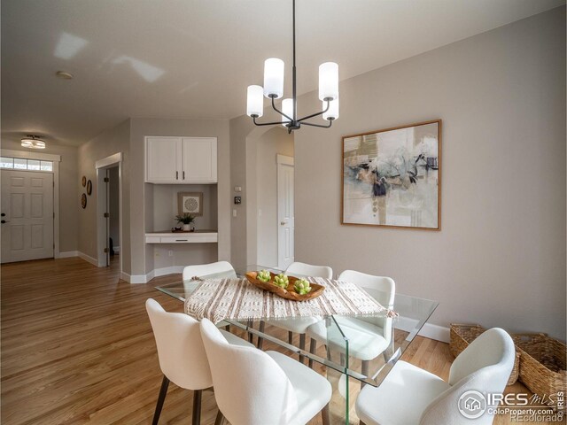 2946 Shoshone Trl, Lafayette, CO 80026 - dining area with baseboards, a chandelier, and light wood finished floors