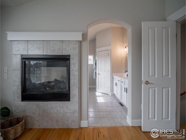 2946 Shoshone Trl, Lafayette, CO 80026 - interior space with arched walkways, a fireplace, wood finished floors, a sink, and baseboards