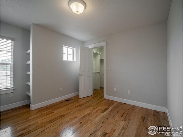 2946 Shoshone Trl, Lafayette, CO 80026 - unfurnished bedroom featuring baseboards, visible vents, and light wood finished floors