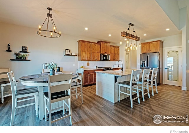 27857 Hopi Trl, Loveland, CO 80534 - kitchen featuring an inviting chandelier, tasteful backsplash, stainless steel appliances, and dark wood-style floors