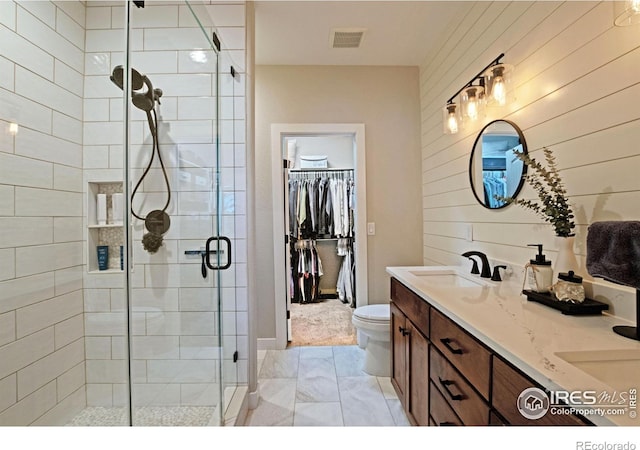 27857 Hopi Trl, Loveland, CO 80534 - bathroom featuring double vanity, visible vents, a sink, a walk in closet, and a stall shower