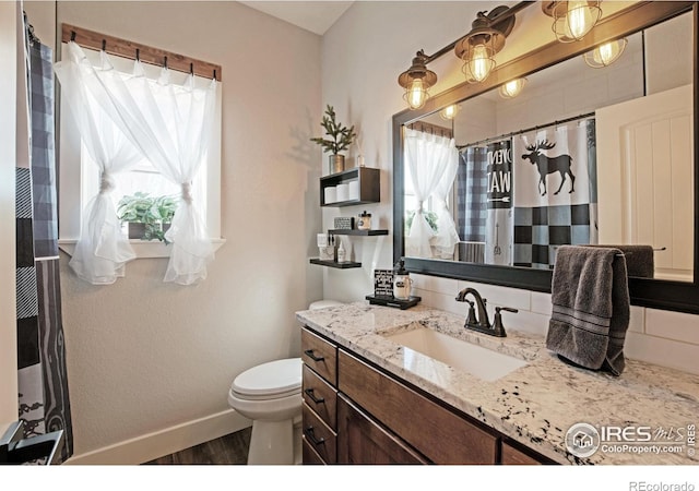 27857 Hopi Trl, Loveland, CO 80534 - bathroom featuring plenty of natural light, vanity, toilet, and baseboards
