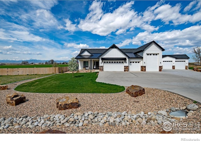 27857 Hopi Trl, Loveland, CO 80534 - view of front of property featuring fence, concrete driveway, stone siding, a front yard, and a garage