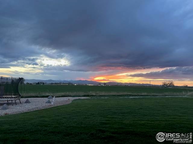 27857 Hopi Trl, Loveland, CO 80534 - yard at dusk with a trampoline