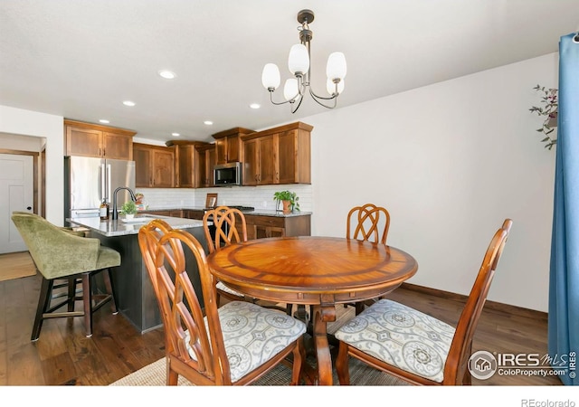 3362 Buffalo Grass Ln, Wellington, CO 80549 - dining room with a chandelier, dark wood-style floors, recessed lighting, and baseboards