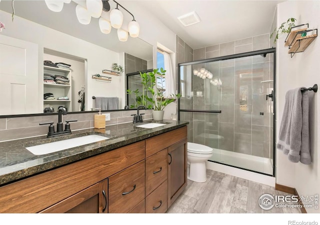 3362 Buffalo Grass Ln, Wellington, CO 80549 - full bath featuring a stall shower, double vanity, toilet, and wood finished floors