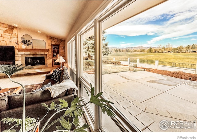 7155 Rustic Trl, Boulder, CO 80301 - living room featuring lofted ceiling, a fireplace, a mountain view, and a view of rural / pastoral area