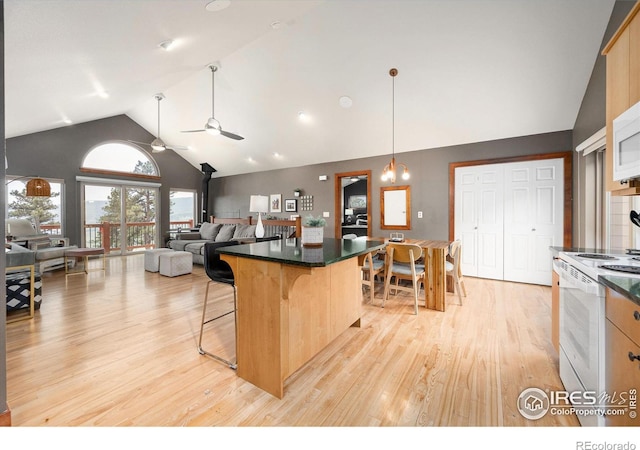 10435 Roan Mountain Rd, Loveland, CO 80538 - kitchen featuring a ceiling fan, a kitchen breakfast bar, light wood-type flooring, white electric range, and dark countertops