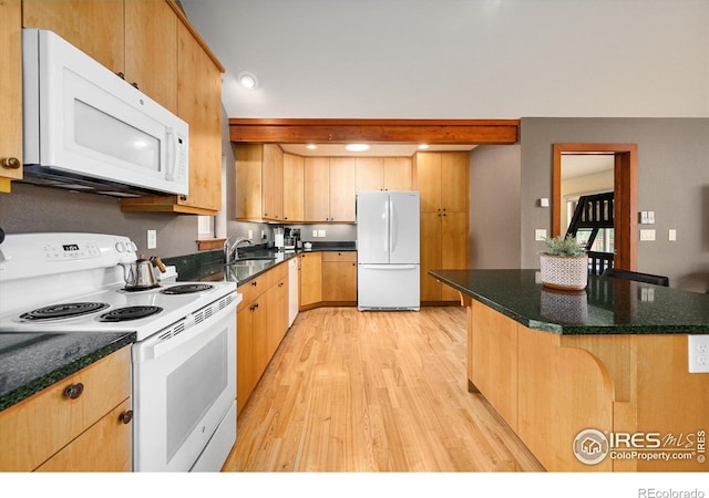 10435 Roan Mountain Rd, Loveland, CO 80538 - kitchen featuring light wood finished floors, white appliances, a sink, a kitchen breakfast bar, and light brown cabinetry