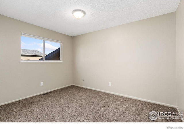 carpeted spare room featuring a textured ceiling, baseboards, and visible vents