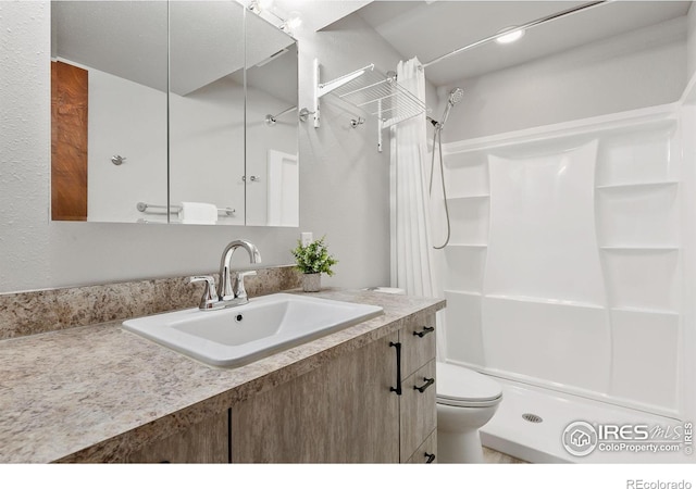bathroom featuring toilet, vanity, and curtained shower